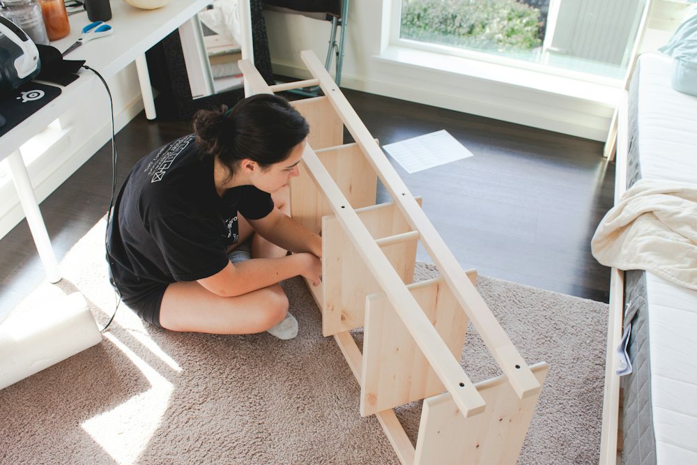 Woman assembling a wooden shelf